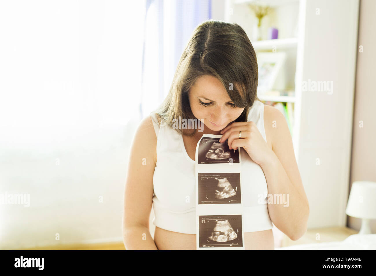 Schöne schwangere Frau mit Ultraschall Scan Bild Stockfoto