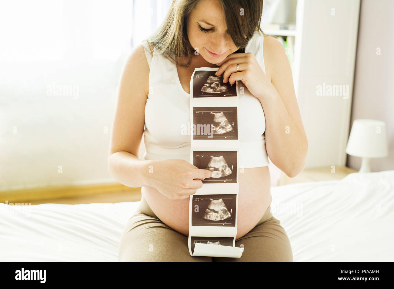 Schöne schwangere Frau mit Ultraschall Scan Bild Stockfoto