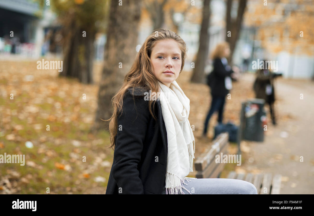 Junge Frau nimmt Rest im Stadtpark Stockfoto