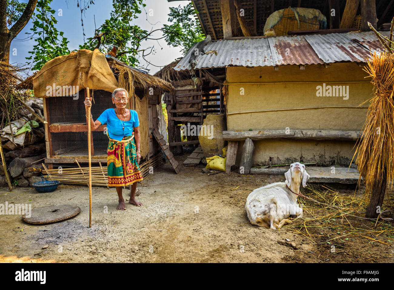 Sehr alte nepalesische Frau und ihre Ziege im Hinterhof ihres Hauses Stockfoto