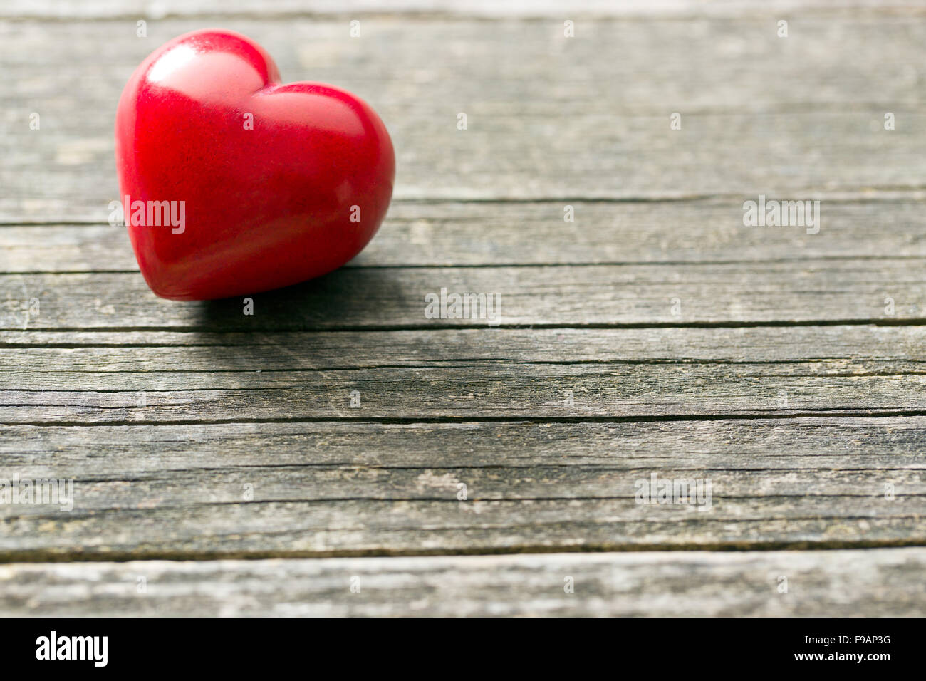roten Stein Herz auf alten hölzernen Hintergrund Stockfoto