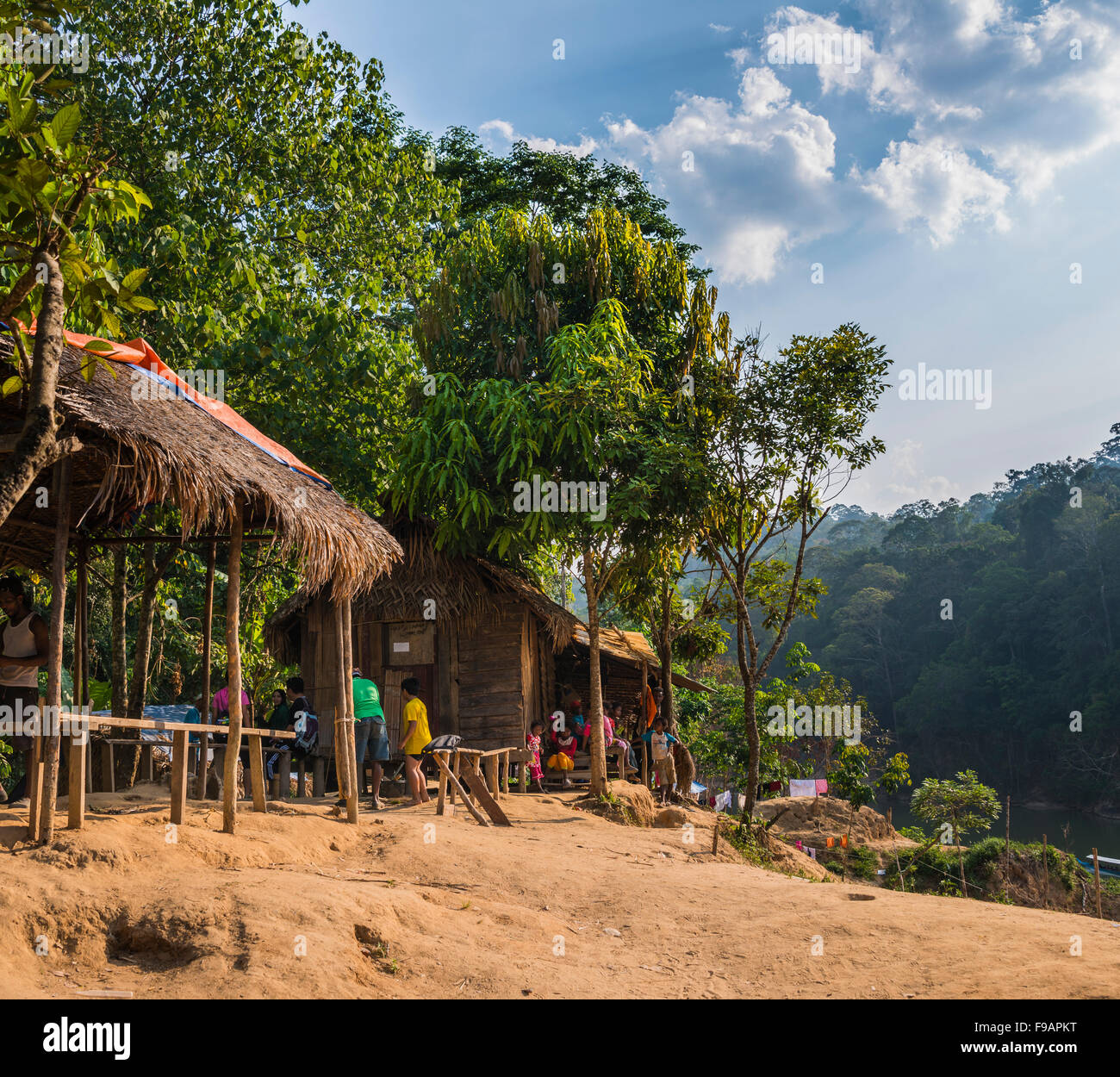 Menschen sitzen vor Holzhütten, Aborigine Orang Asil-Stamm, Naturvolk, Taman Negara, Malaysia Stockfoto