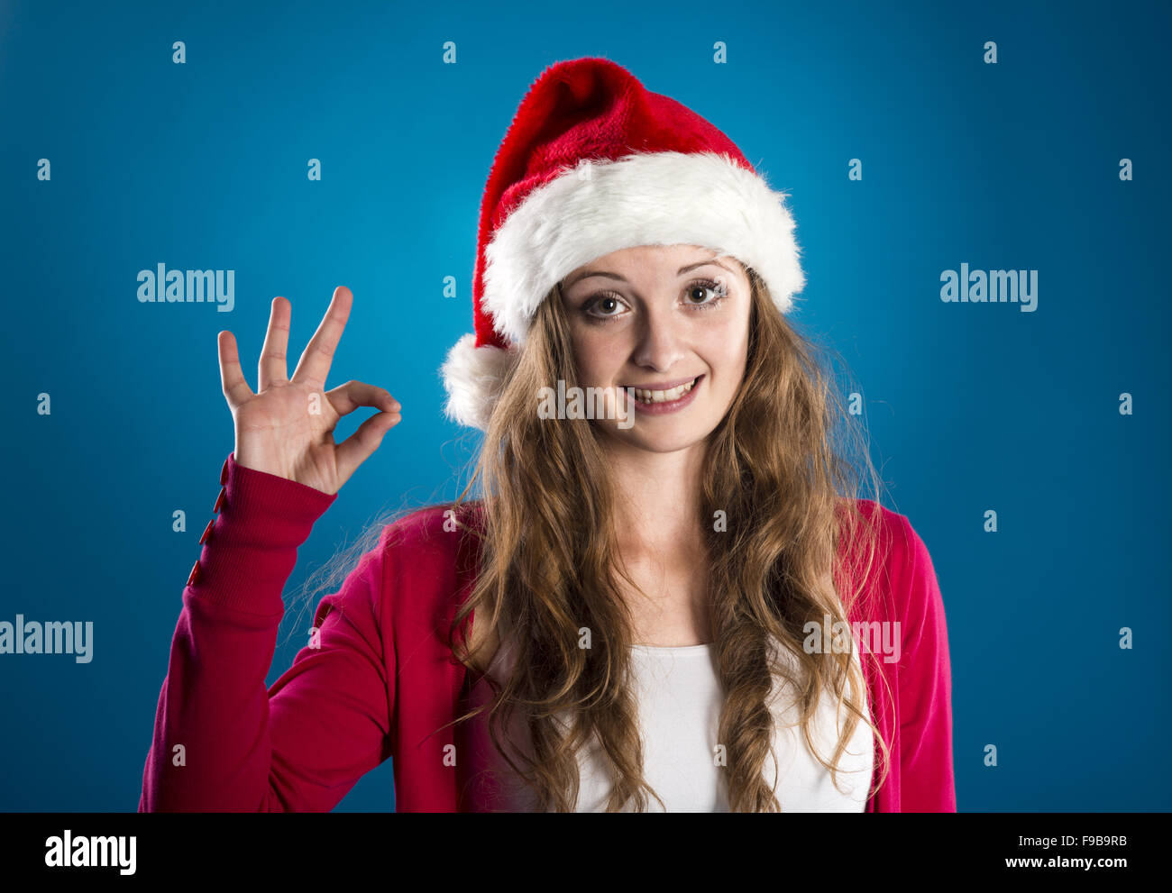 Porträt von attraktiven Frau isoliert auf blau, Studio gedreht in Weihnachtsmütze Stockfoto