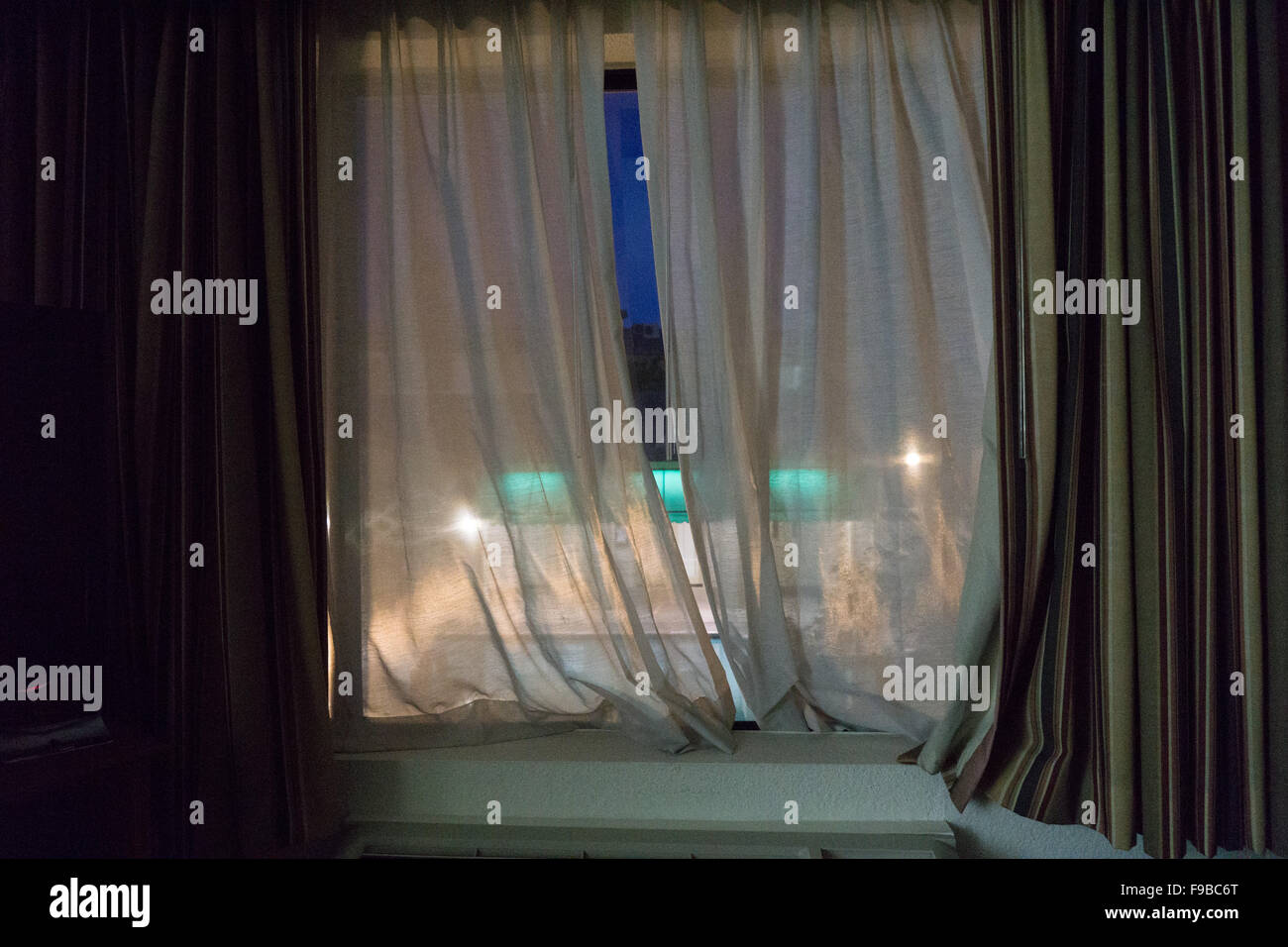Gardinen in einem Motelzimmer in der Nacht Stockfoto