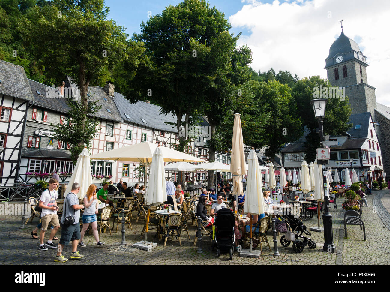 Touristen besuchen Straßencafés auf dem Marktplatz in der Stadt Monschau / Eifel-Region / Deutschland. Stockfoto