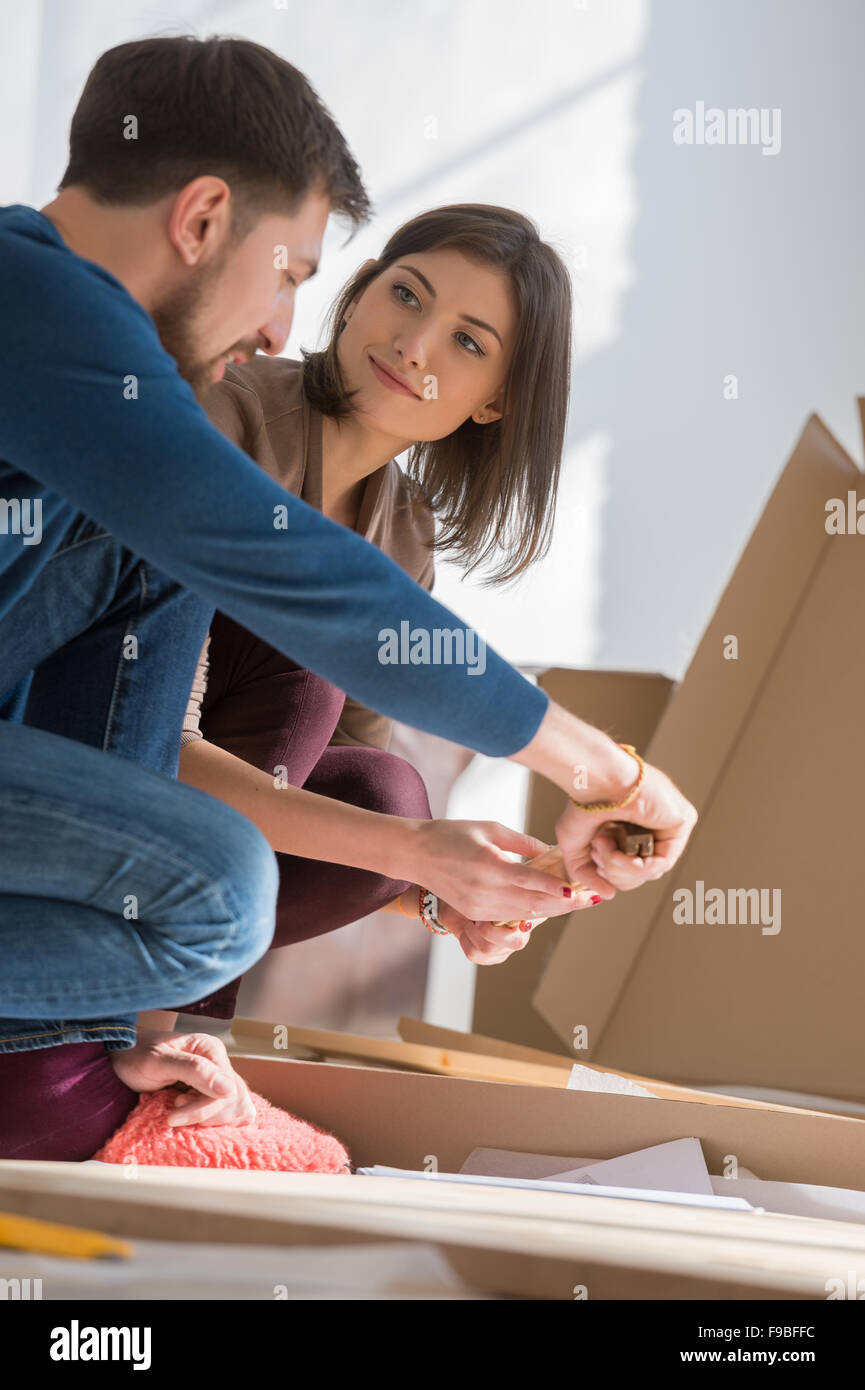 Glückliches junges Paar Selbstmontage Möbel zusammenstellen, wie sie in ihr neues Haus zu bewegen. Stockfoto