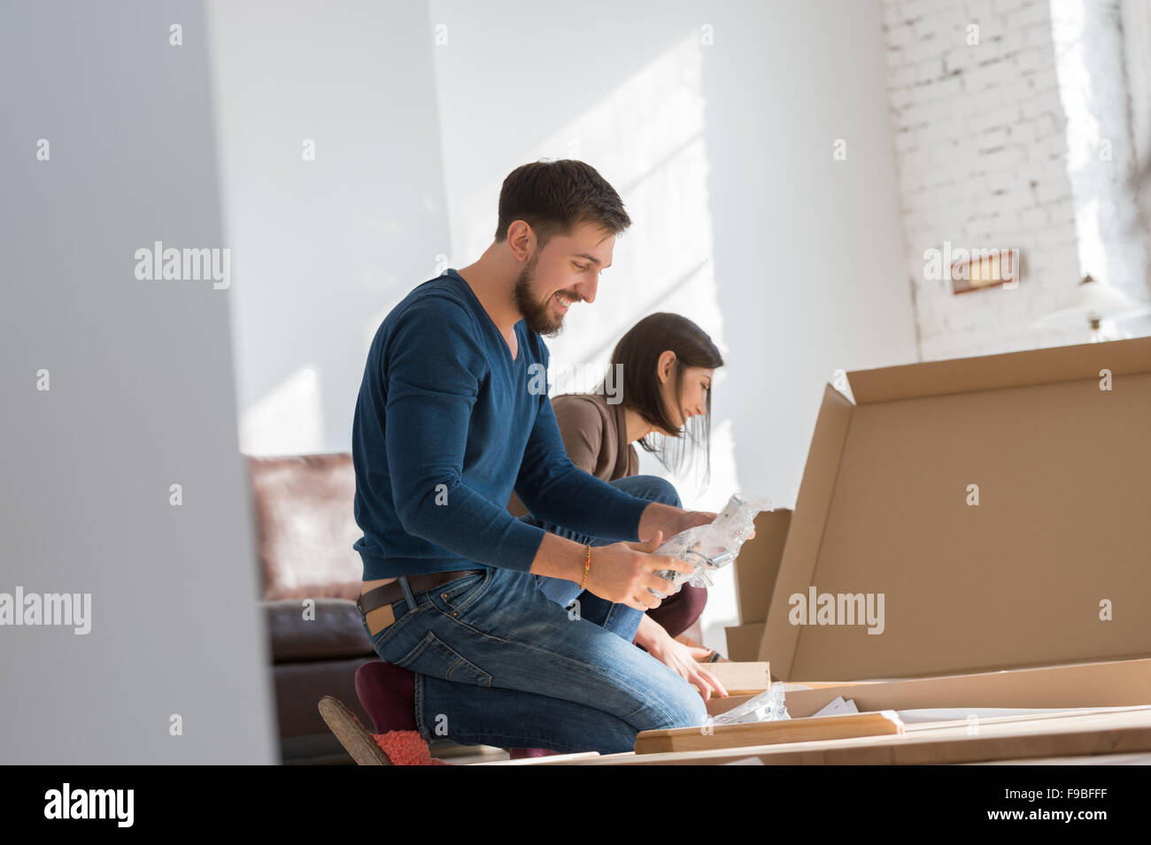 Glückliches junges Paar Selbstmontage Möbel zusammenstellen, wie sie in ihr neues Haus zu bewegen. Stockfoto