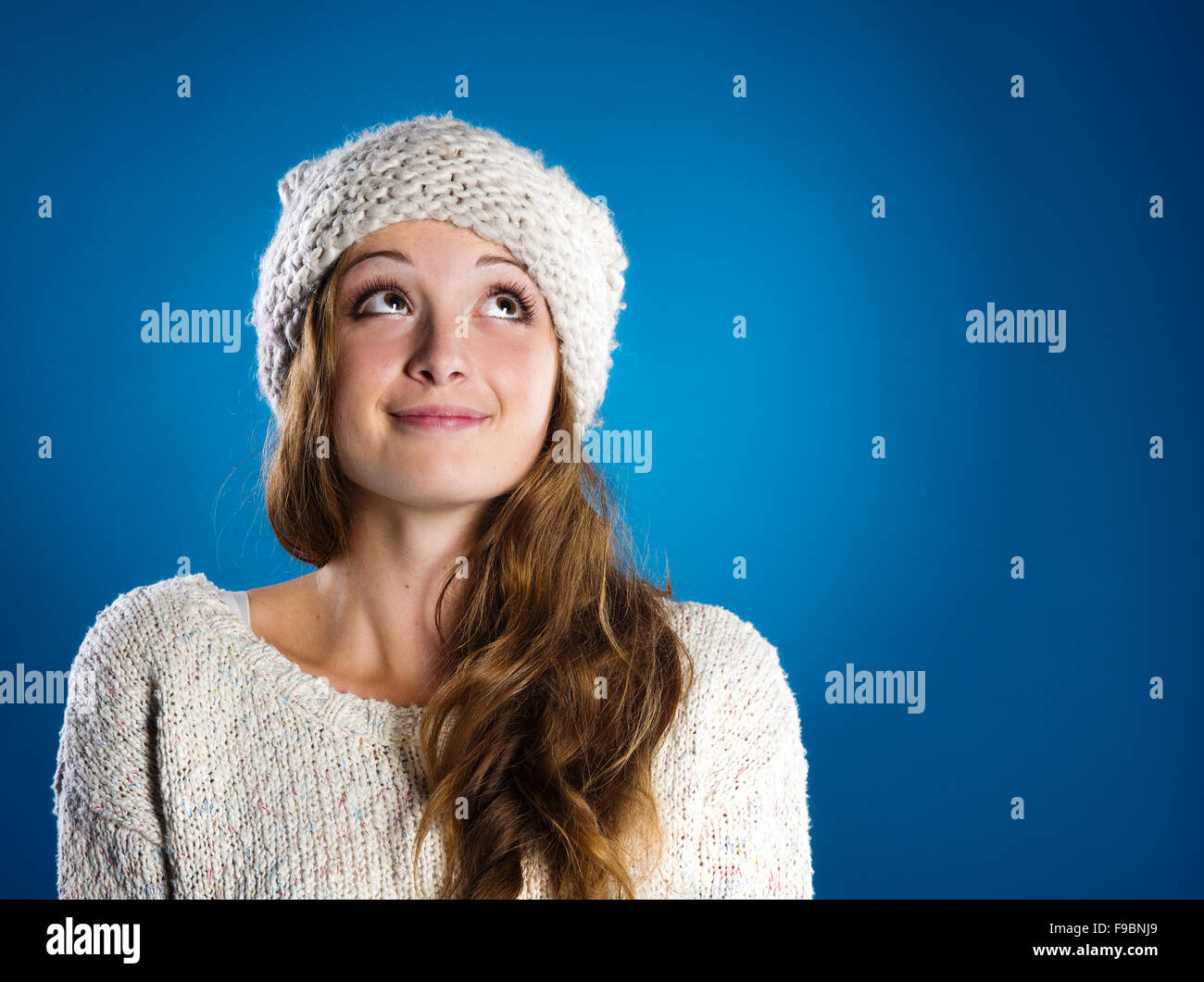 Schöne Frau im warmen Pullover auf blauem Hintergrund Stockfoto