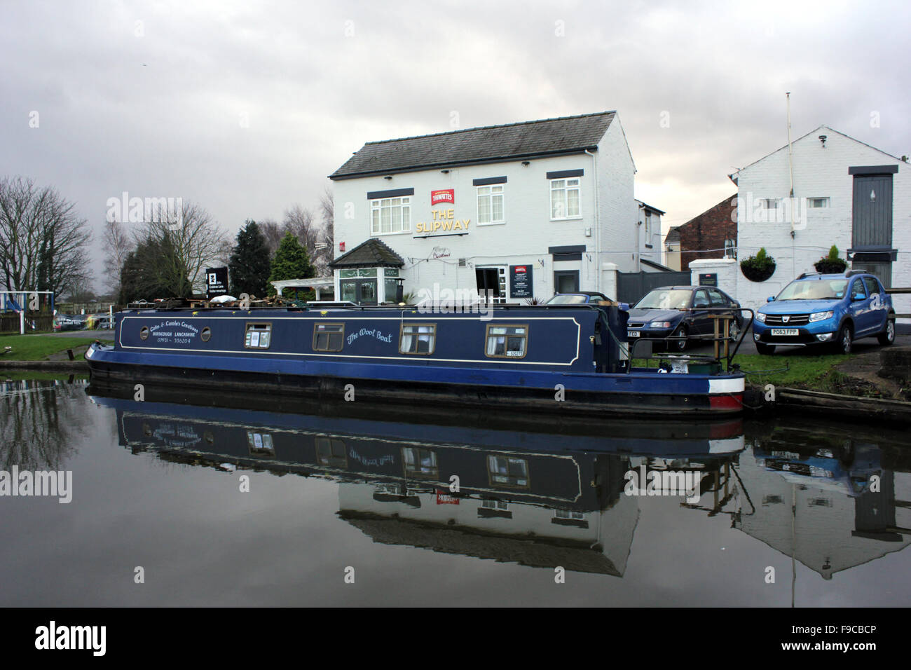 Die Slipanlage Pub am Leeds und Liverpool Kanal in West Lancashire mit einem Boot vor Anker außerhalb Stockfoto