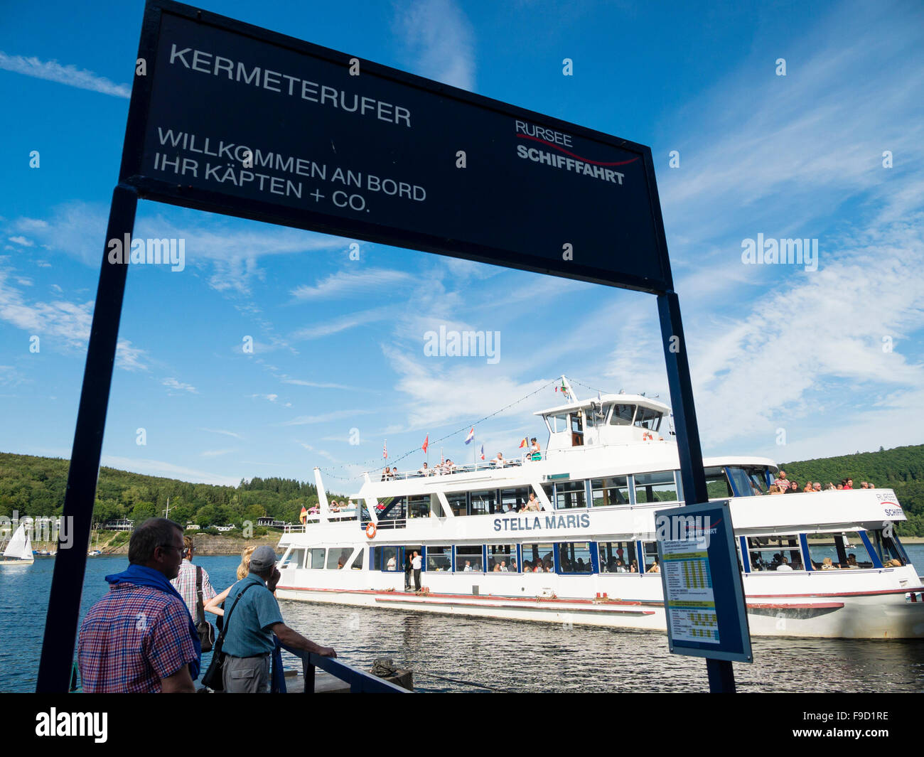 Touristen an den Ufern des Sees Rursee warten auf die Ankunft von einem Passagierschiff in der deutschen Eifel-Nationalpark. Stockfoto