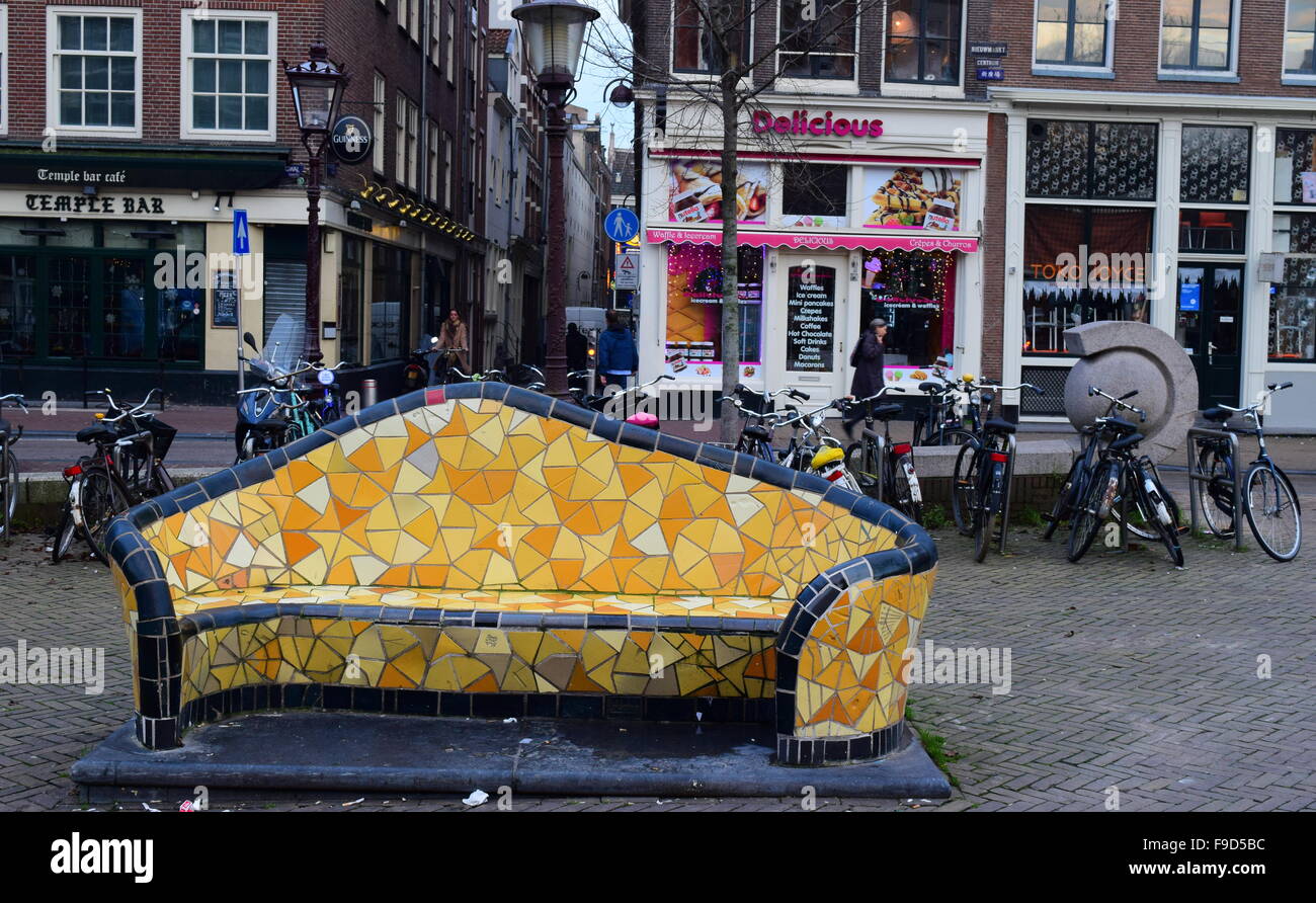 Eine skurrile und hellen gelben Fliesen/Keramik künstlerische Darstellung einer Bank in der Mitte eines kleinen Platzes in Amsterdam. Stockfoto