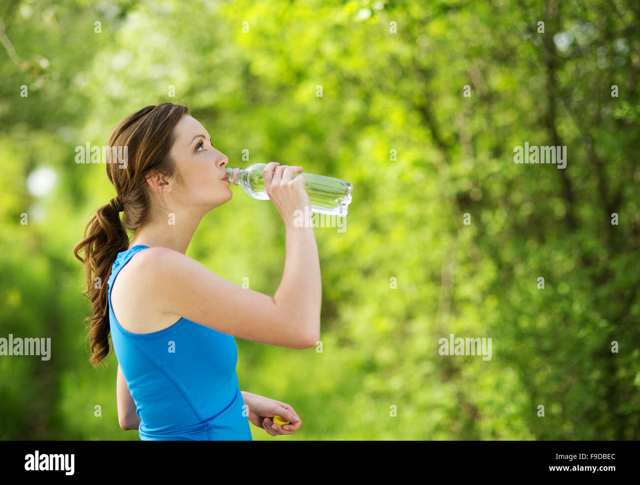 Athlet erfrischend, mit einer Flasche Wasser während der Bewegung im freien Stockfoto