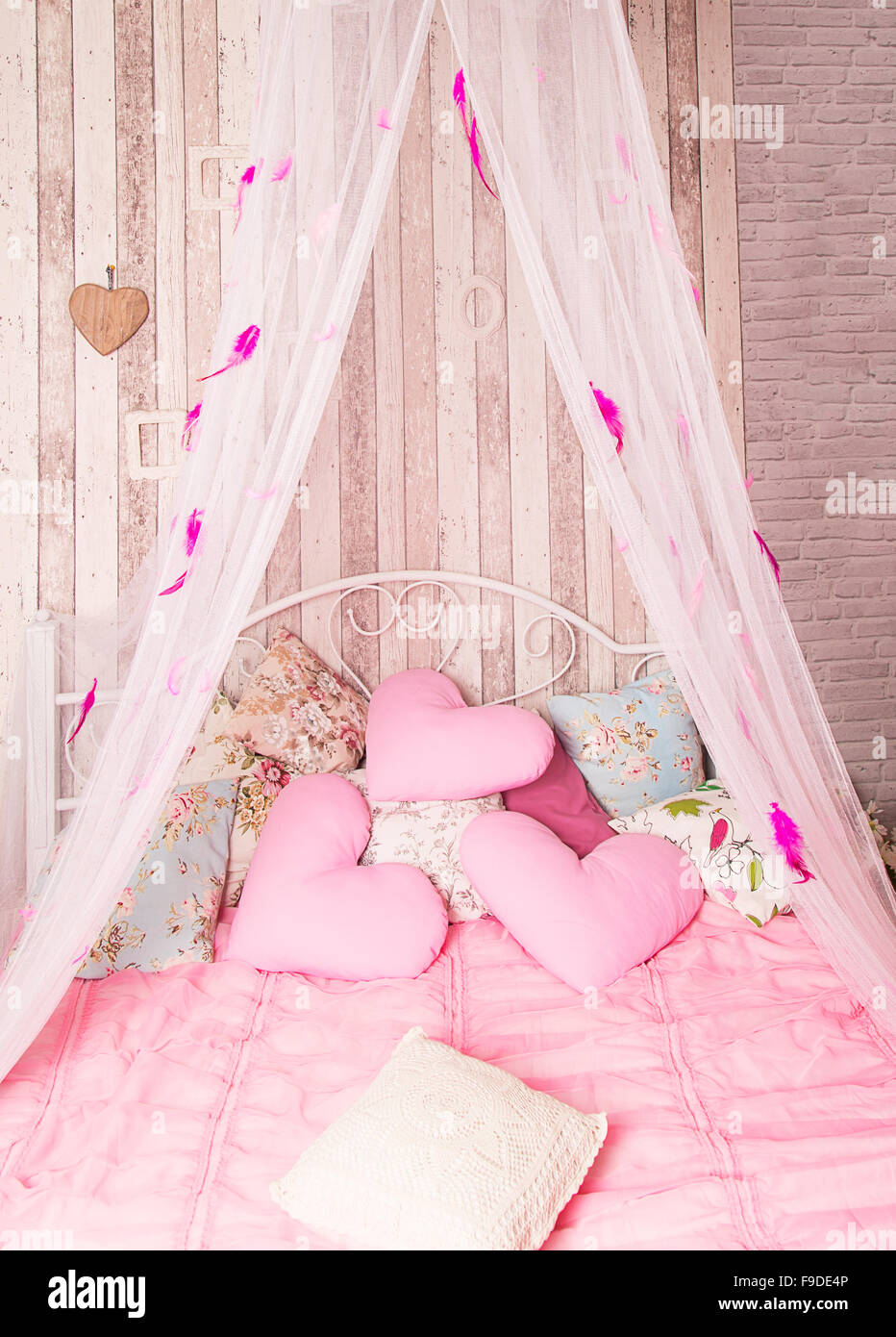 Himmelbett mit rosa Kissen im studio Stockfotografie