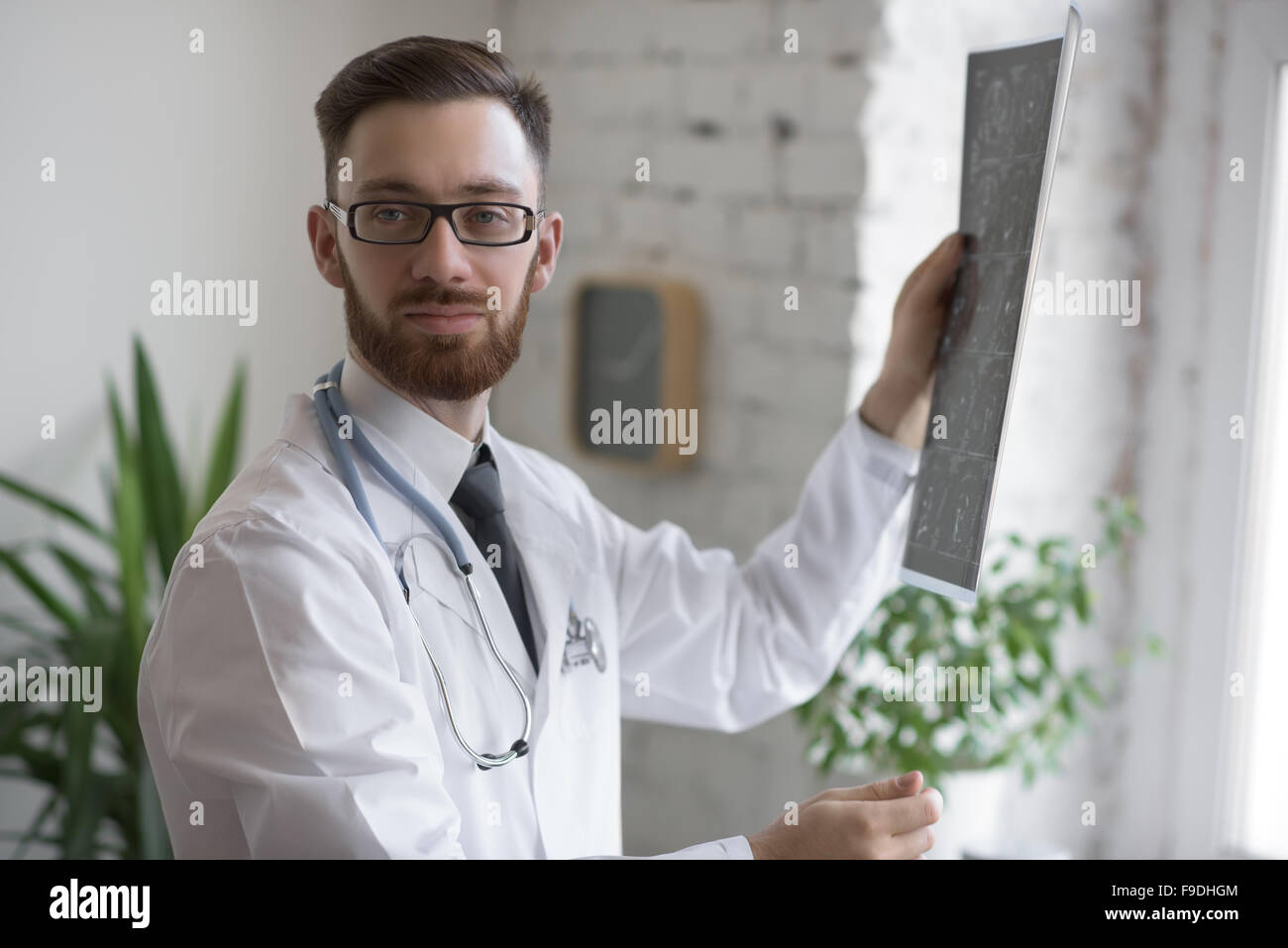 Closeup Portrait des Pflegepersonals intellektuellen Mann mit weißen Laborkittel, Blick auf Gehirn Röntgen Röntgenbild, Ct-scan Stockfoto