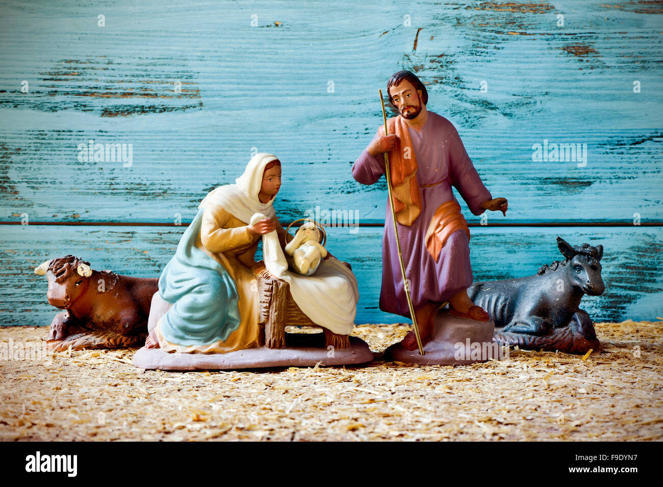 die Heilige Familie, Jesuskind, der Jungfrau Maria und St. Joseph, und der Esel und Ochsen in eine rustikale Weihnachtskrippe Stockfoto