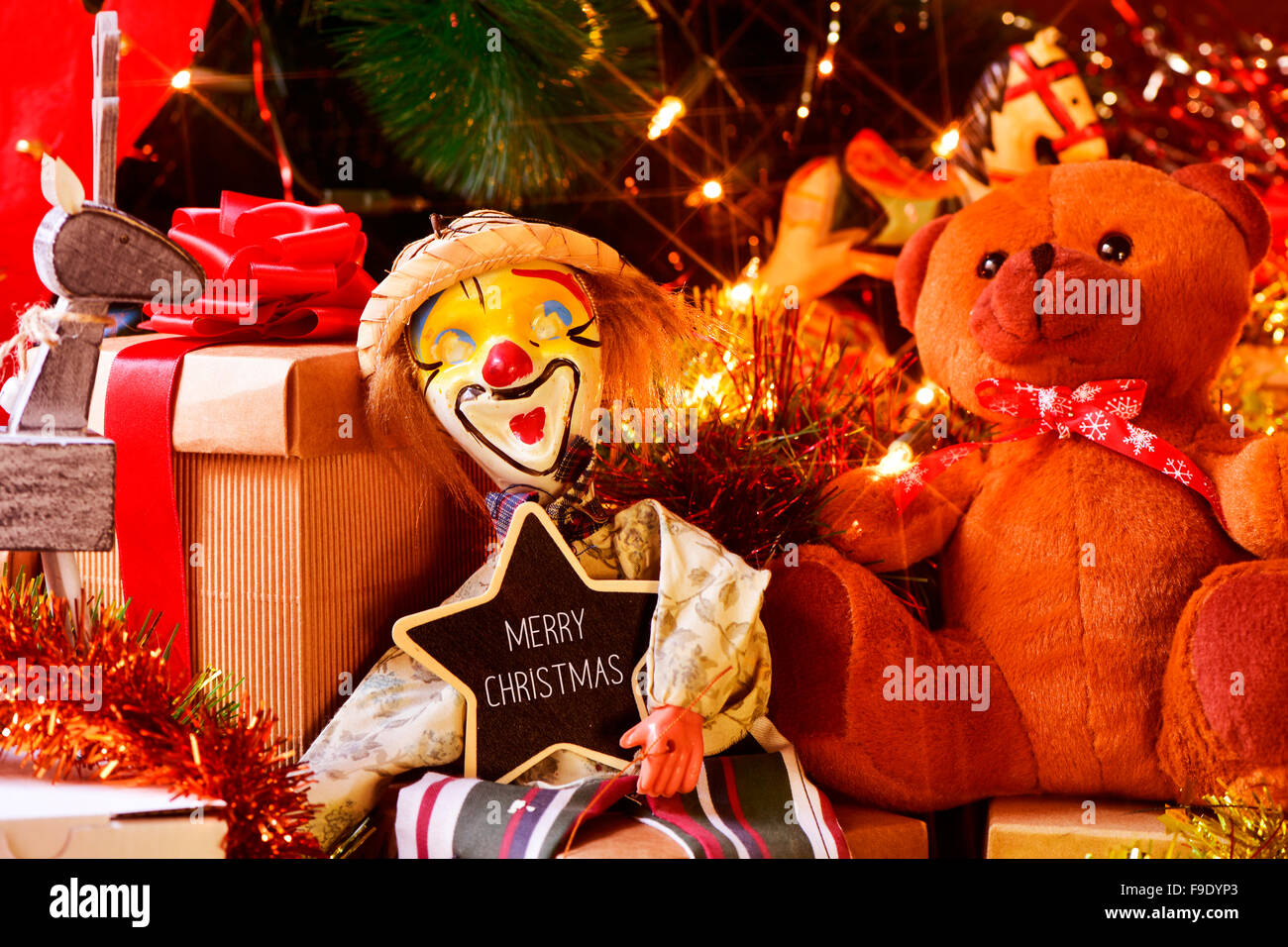 Nahaufnahme von einem sternförmigen Tafel mit dem Text Frohe Weihnachten und einige Geschenke und Retro Spielzeug, wie eine Marionette oder einen Teddy Stockfoto