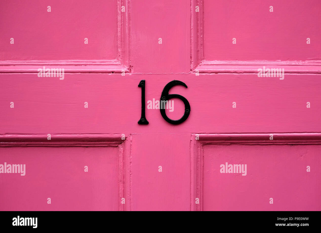sechzehn auf rosa lackierten vorderen Tür Stockfoto