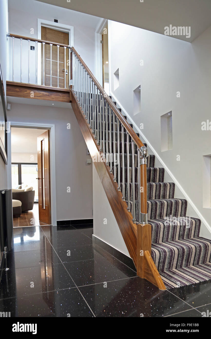 inländische Treppe in einem frisch renovierten Londoner Haus mit Holz und Metall-Geländer, Fliesenboden und einen gestreiften Treppe Teppich Stockfoto