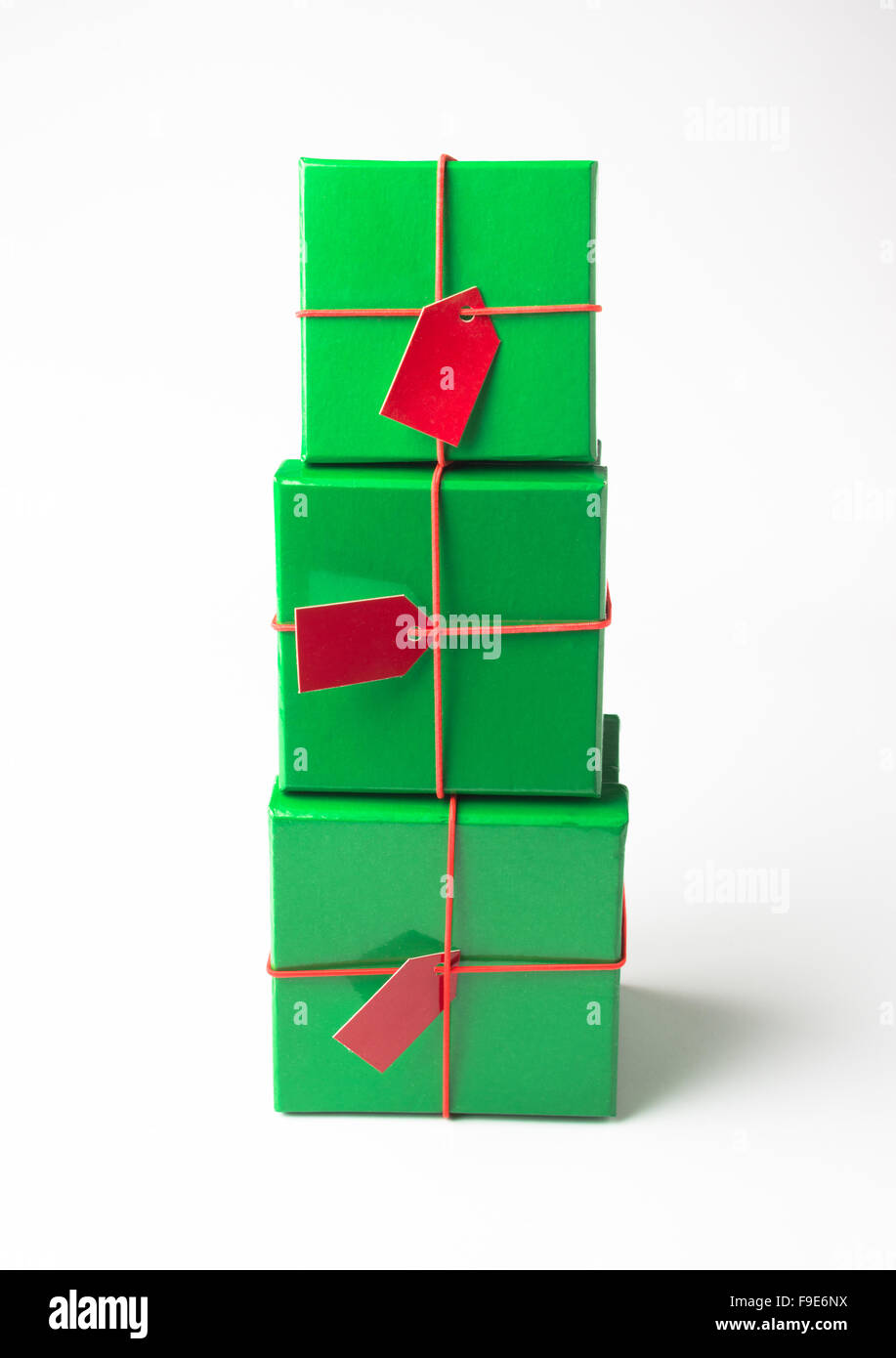 Einer vertikalen Stapel von drei grüne Farbe festliche Geschenk-Boxen auf weißem Hintergrund. Stockfoto