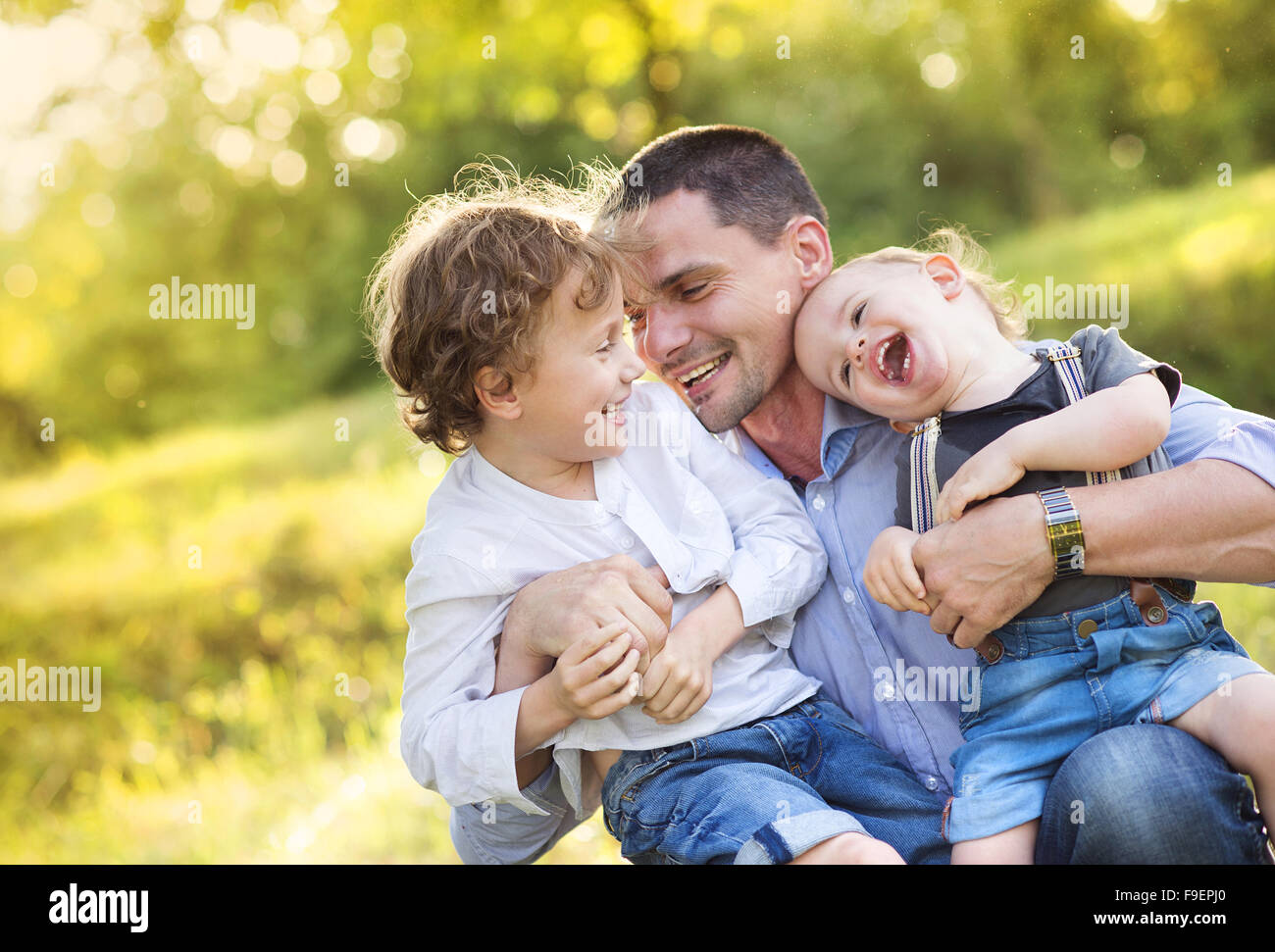 Kleine Jungs und ihren Papa genießen ihre Zeit zusammen draußen in der Natur Stockfoto