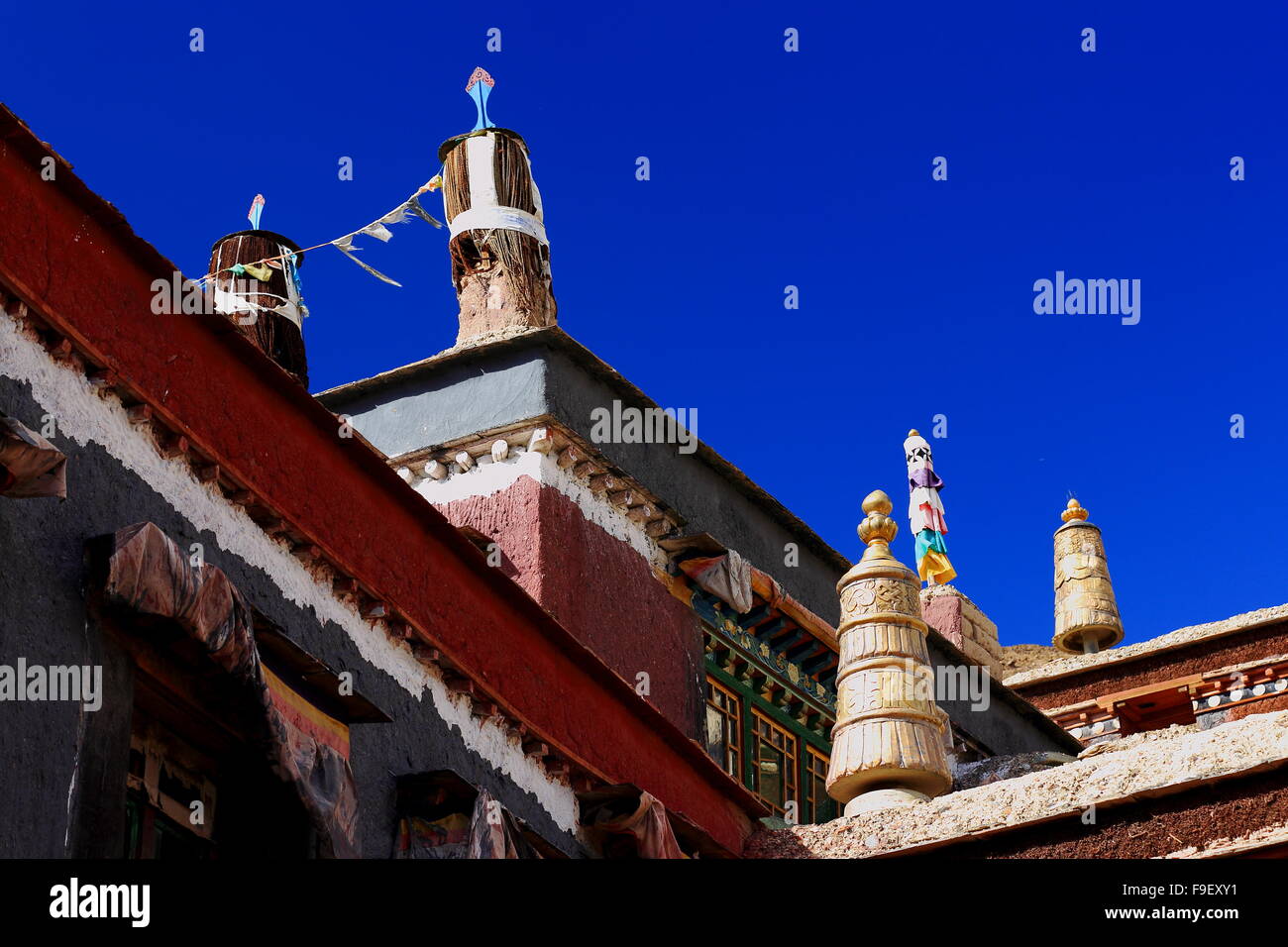 Vergoldetes Messing und Stoff Dhvajas-Sieg Banner auf Dach-blau Stoffvorhang. Schrein auf dem Gelände Sakya Kloster-Tibet. Stockfoto