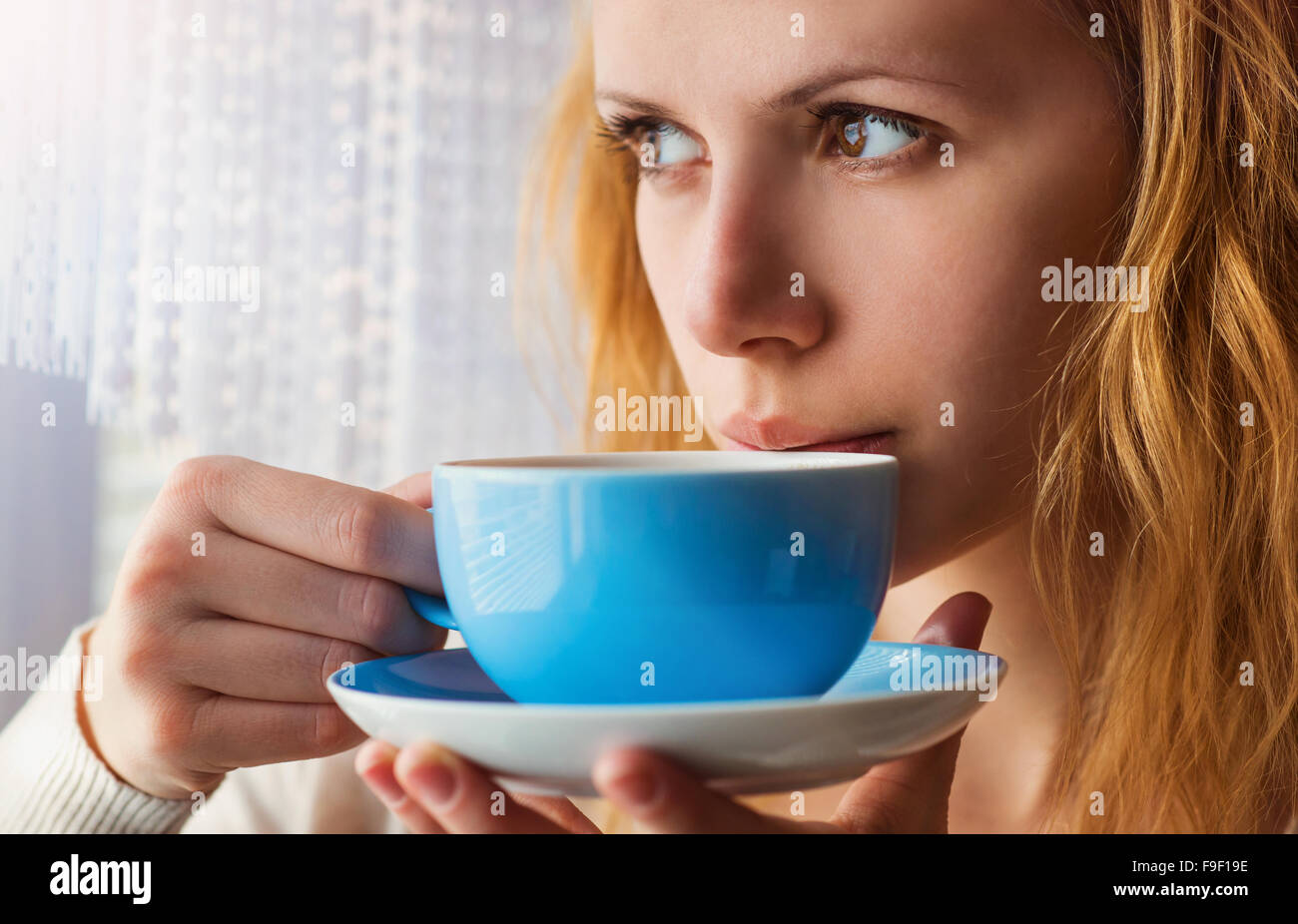 Schöne Frau aus ihrer Tasse Kaffee schlürfen Stockfoto