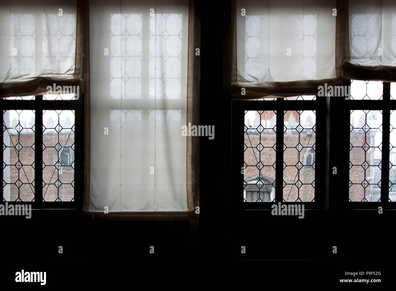 Vier Fenster mit Vorhängen, die auf der Suche Stockfoto