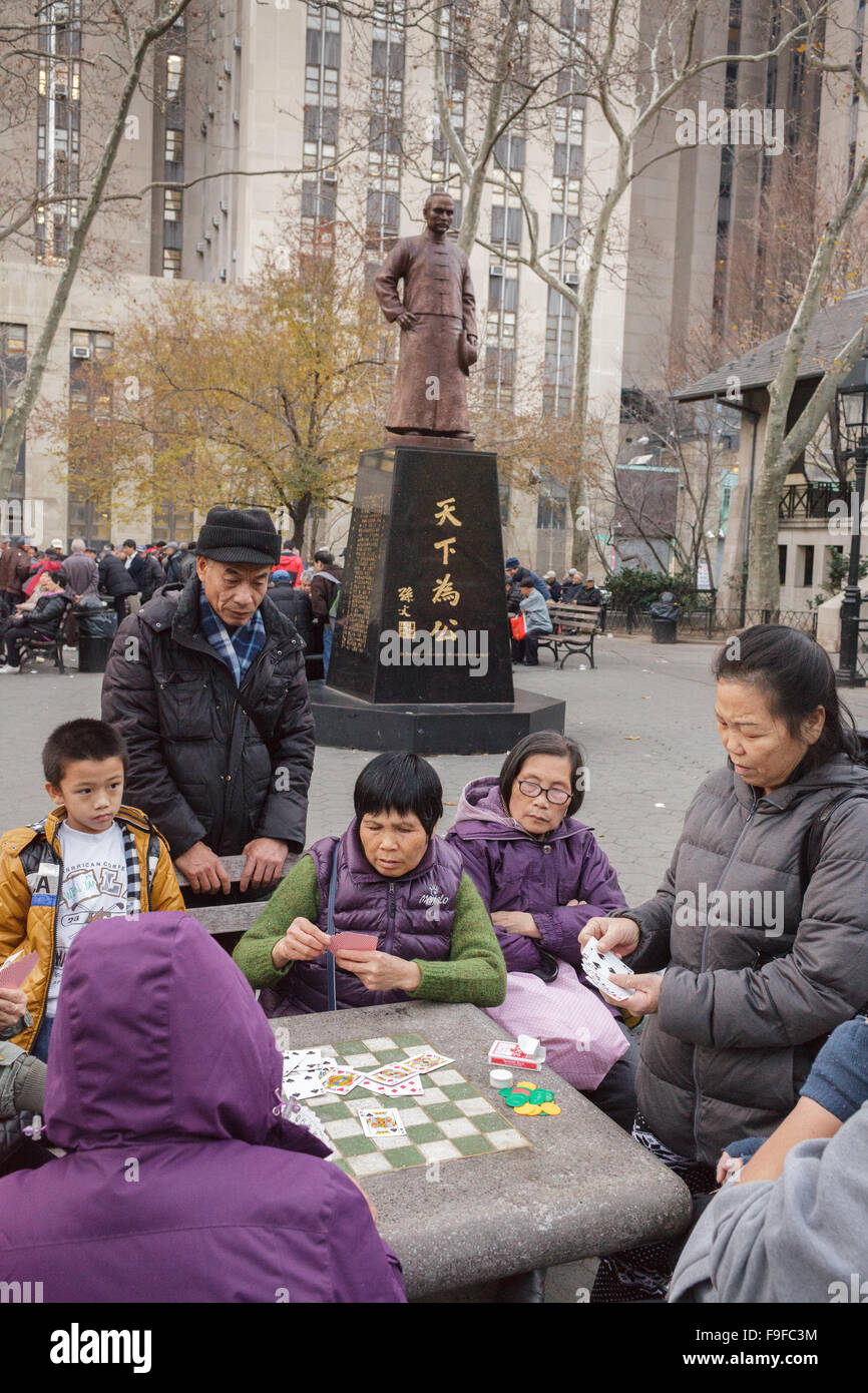 Chinesische spielen Mah-jongg Brettspiele unter Dr. Sun Yat-Sen Statue, Columbus Park, Chinatown, New York City, USA Stockfoto