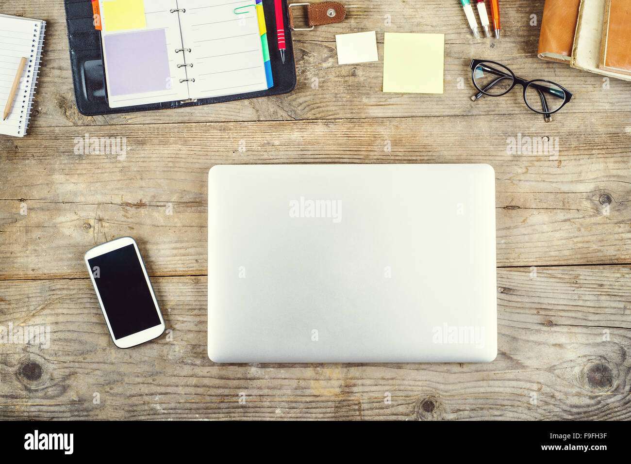 Mix von Bürobedarf und Gadgets auf einem Holztisch Hintergrund. Ansicht von oben. Stockfoto