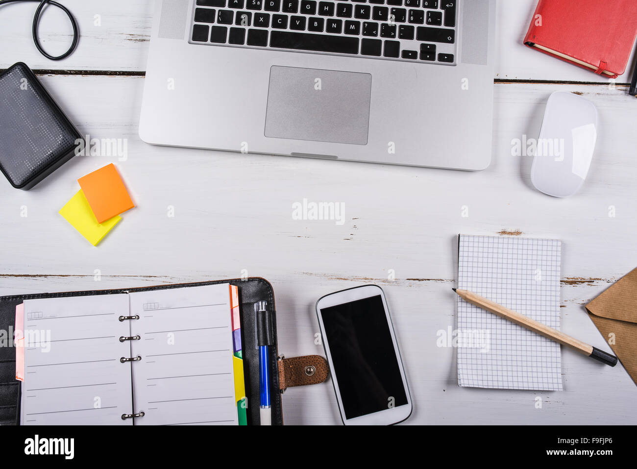 Mix von Bürobedarf und Gadgets auf einem weißen Holztisch Hintergrund. Ansicht von oben. Stockfoto