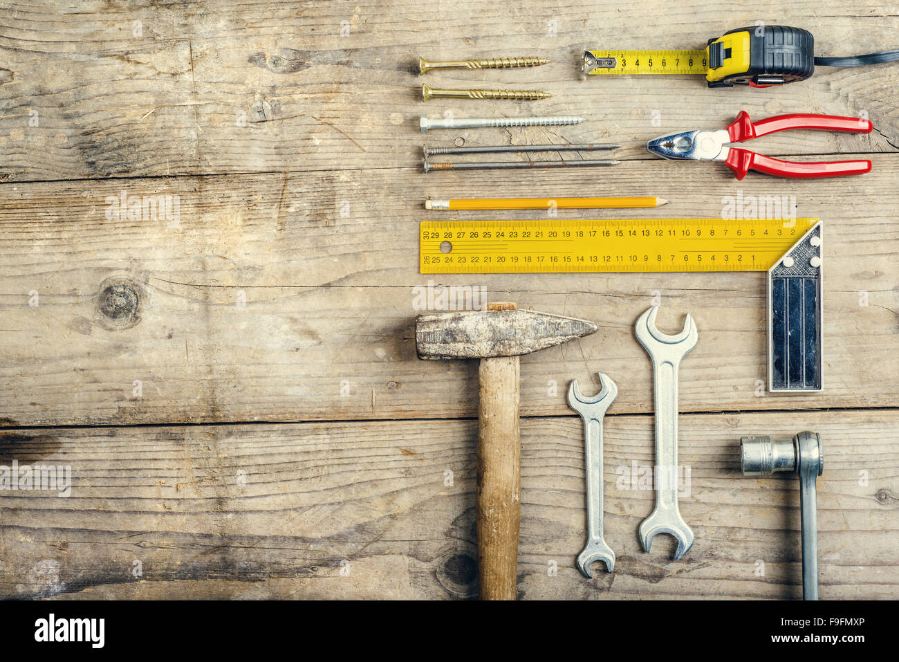 Schreibtisch einer Schreinerei mit verschiedenen Werkzeugen. Studio auf einem hölzernen Hintergrund gedreht. Stockfoto