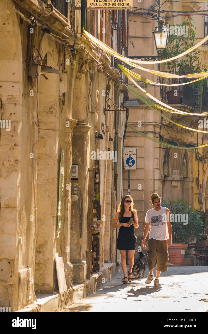 Ein junges Paar reist nach Italien, ein junges Paar macht einen gemütlichen Spaziergang durch eine Straße in der historischen Altstadt einer süditalienischen Stadt. Stockfoto