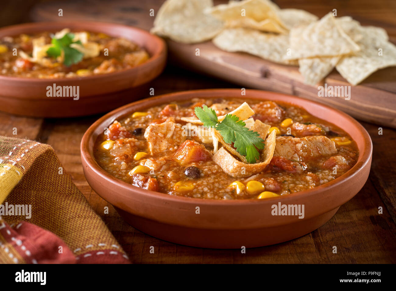 Eine Schüssel mit leckeren hausgemachten Tortilla Hühnersuppe mit Huhn, Mais, schwarze Bohnen, Tomaten, Maismehl und Tortilla. Stockfoto