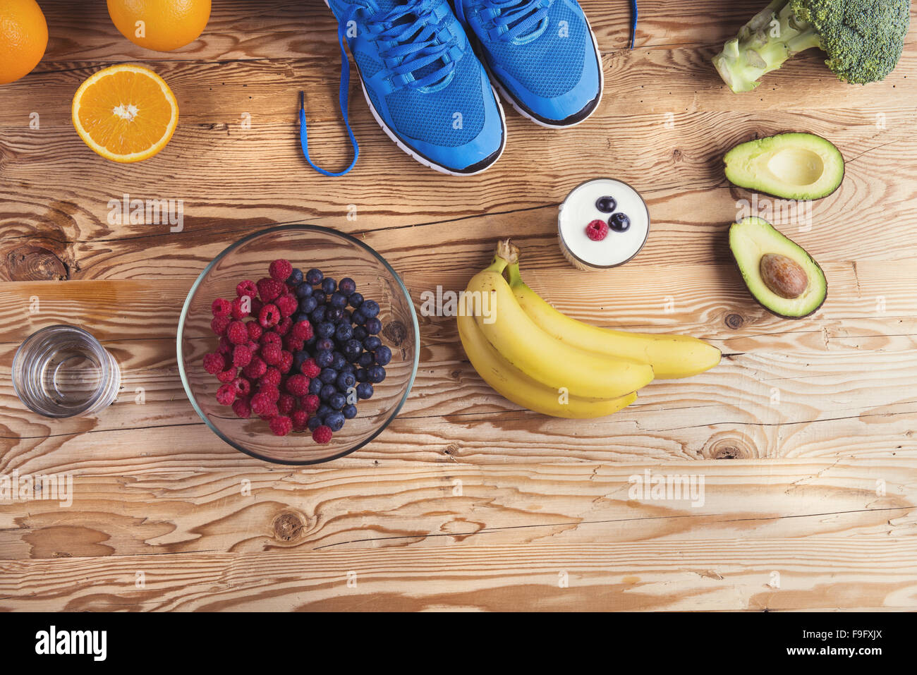 Paar Laufschuhe und gesunde Ernährung Zusammensetzung auf einem Holztisch Hintergrund Stockfoto