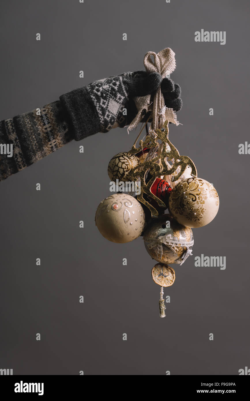 Frau mit handgefertigtem Weihnachtsschmuck vor grauem Hintergrund Stockfoto