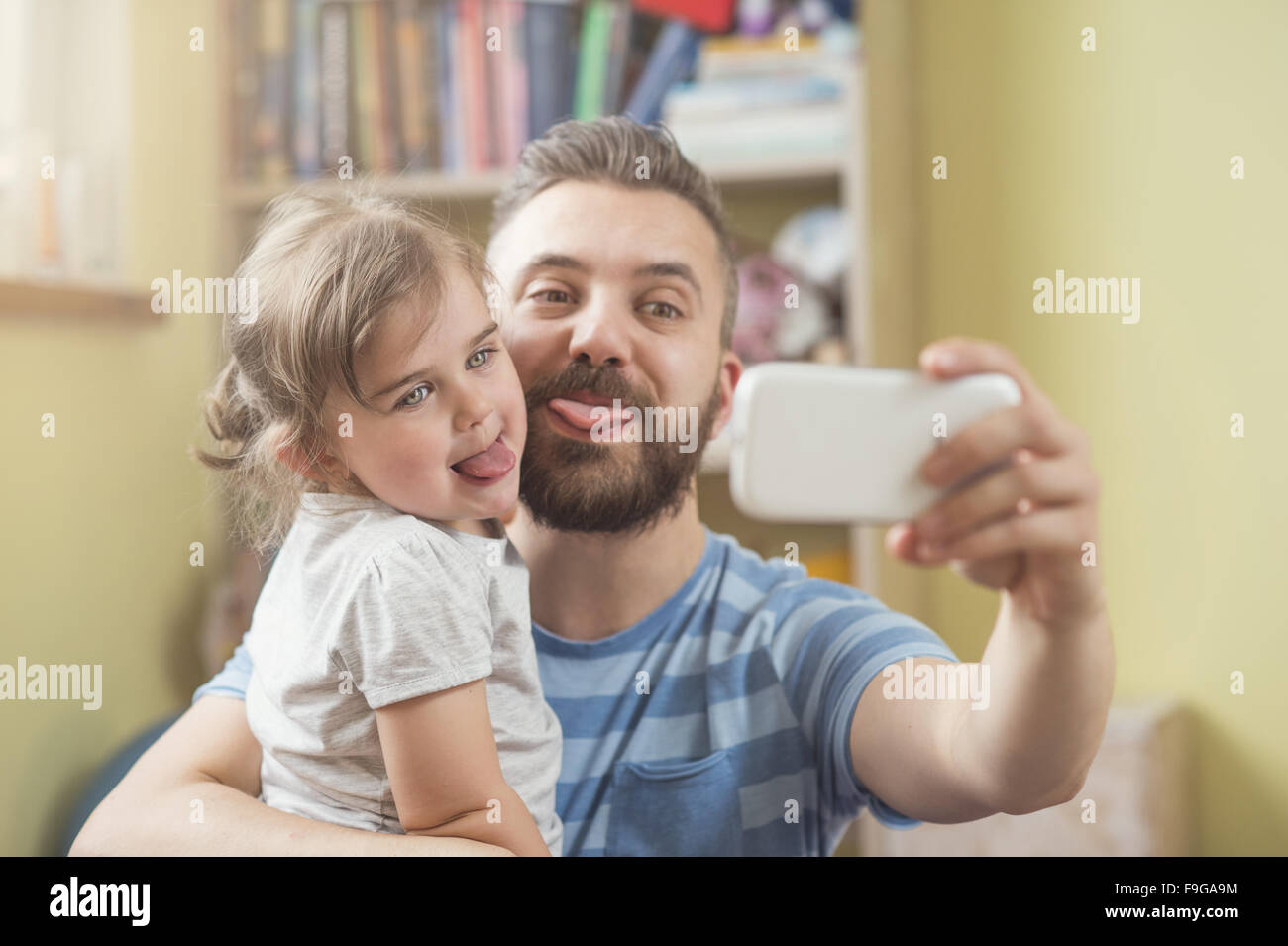 Junger Vater mit seiner niedlichen kleinen Tochter nehmen selfie Stockfoto