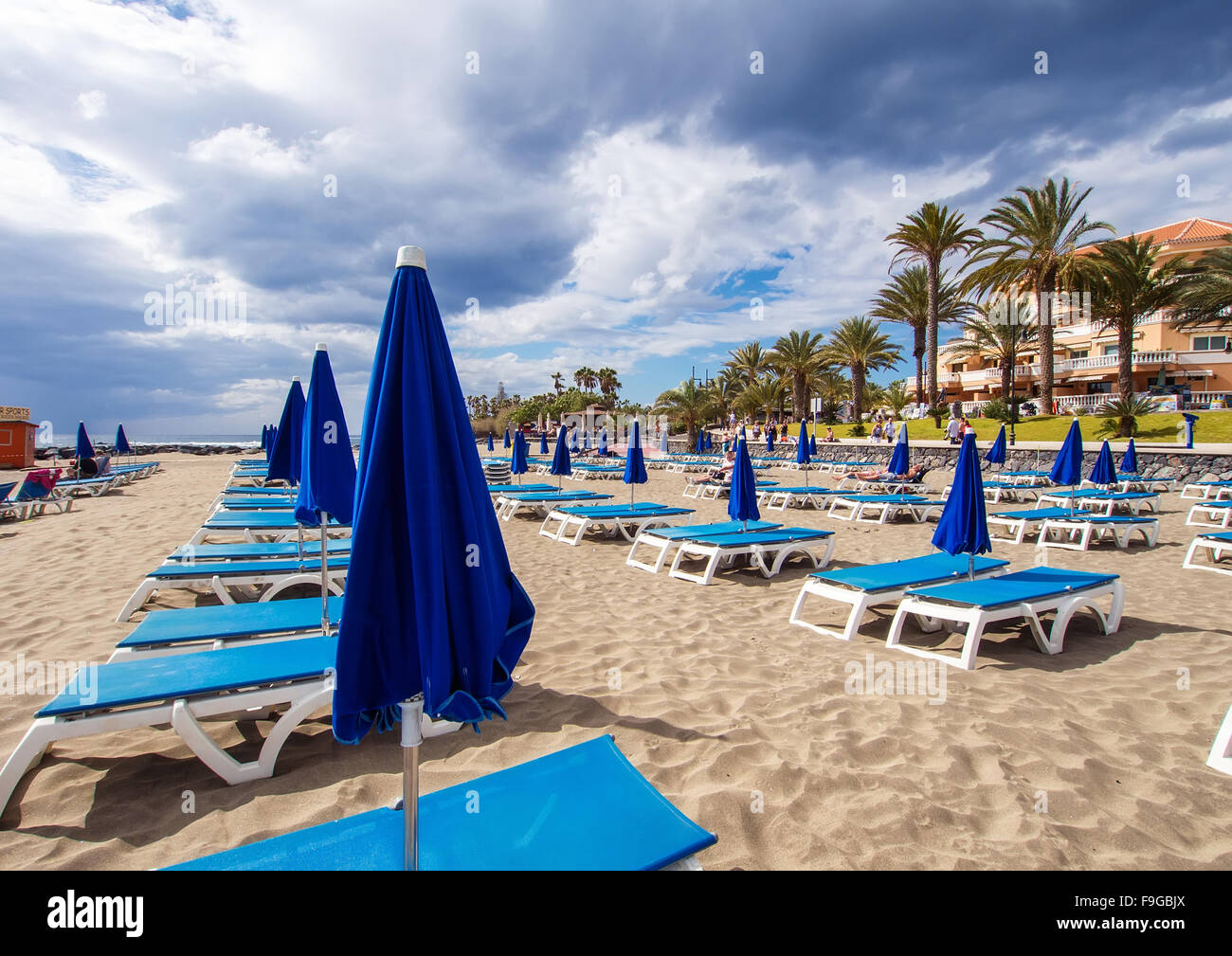 Sonnenliegen und Sonnenschirme am Strand von Los Cristianos, beliebte und bekannte Resort auf Teneriffa. Kanarische Inseln, Spanien Stockfoto