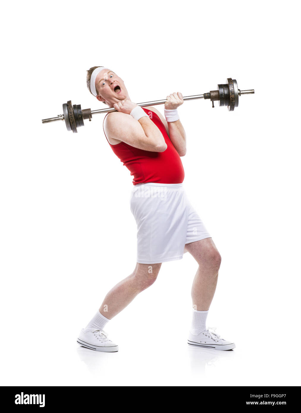 Lustige schwach Bodybuilder versucht, eine Gewicht zu heben. Studio auf weißem Hintergrund gedreht. Stockfoto
