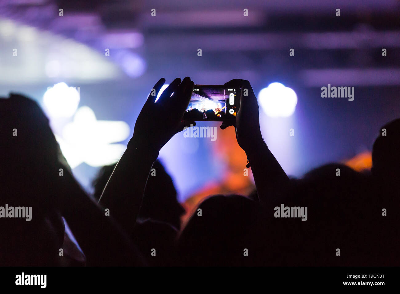Konzertbesucher Einnahme Foto mit dem iPhone Stockfoto