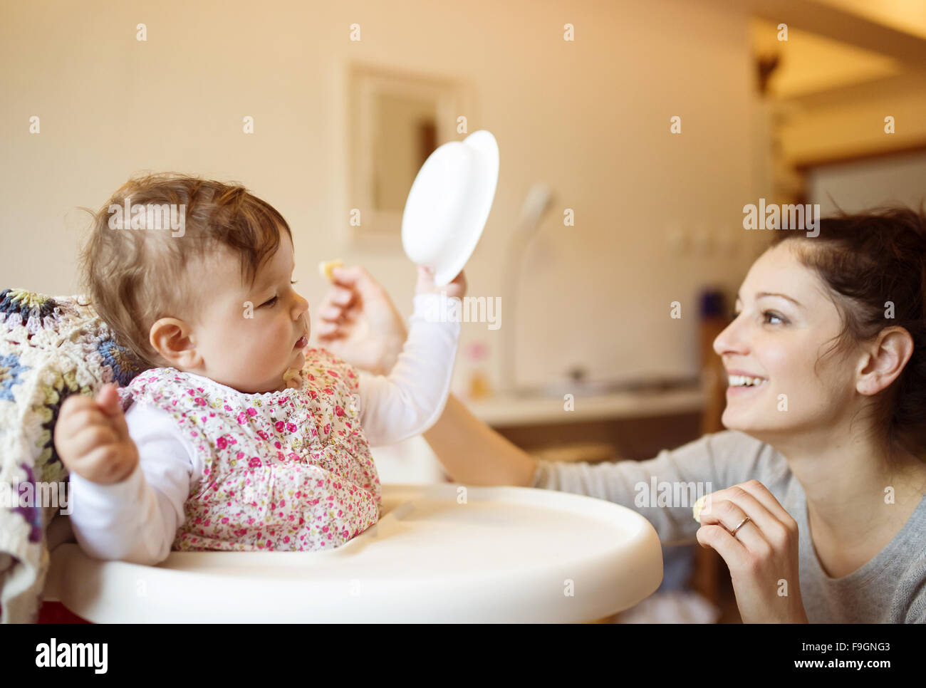 Junge Mutter und ihrer kleinen Tochter zusammen frühstücken Stockfoto