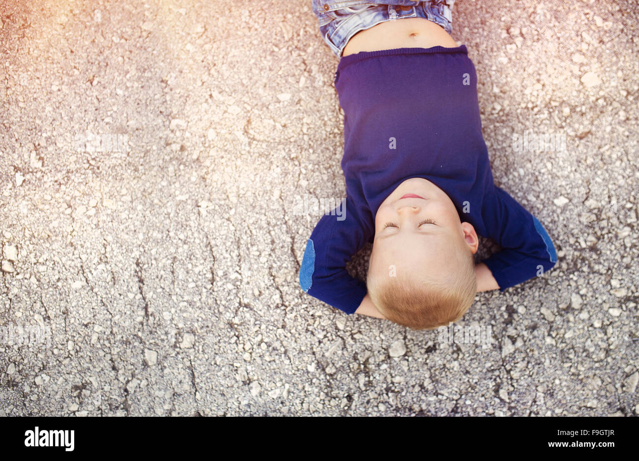 Kleiner Junge auf dem Boden seiner Zeit im Freien genießen Stockfoto