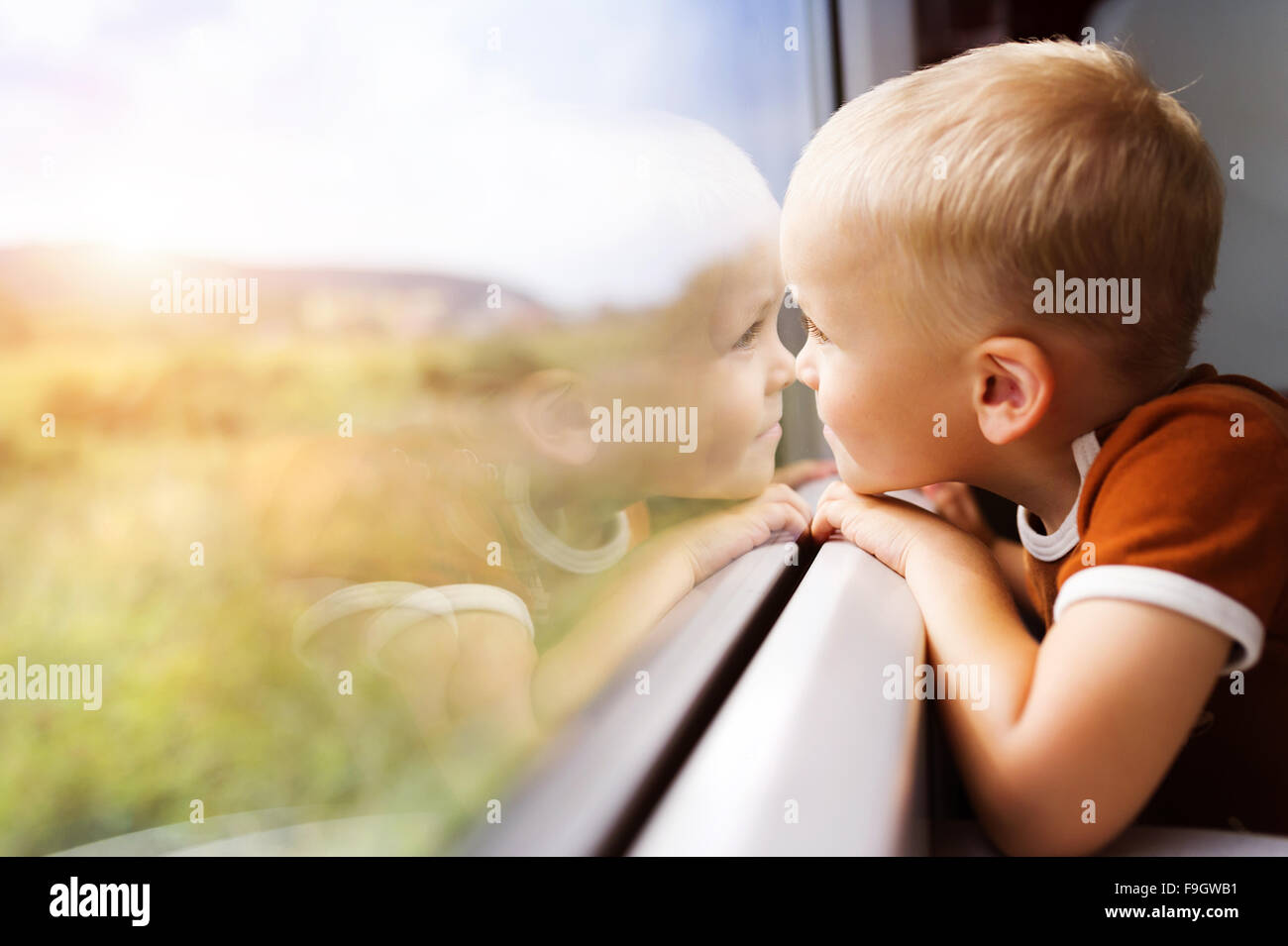 Kleiner Junge Reisen in Zug draußen vor dem Fenster suchen. Stockfoto