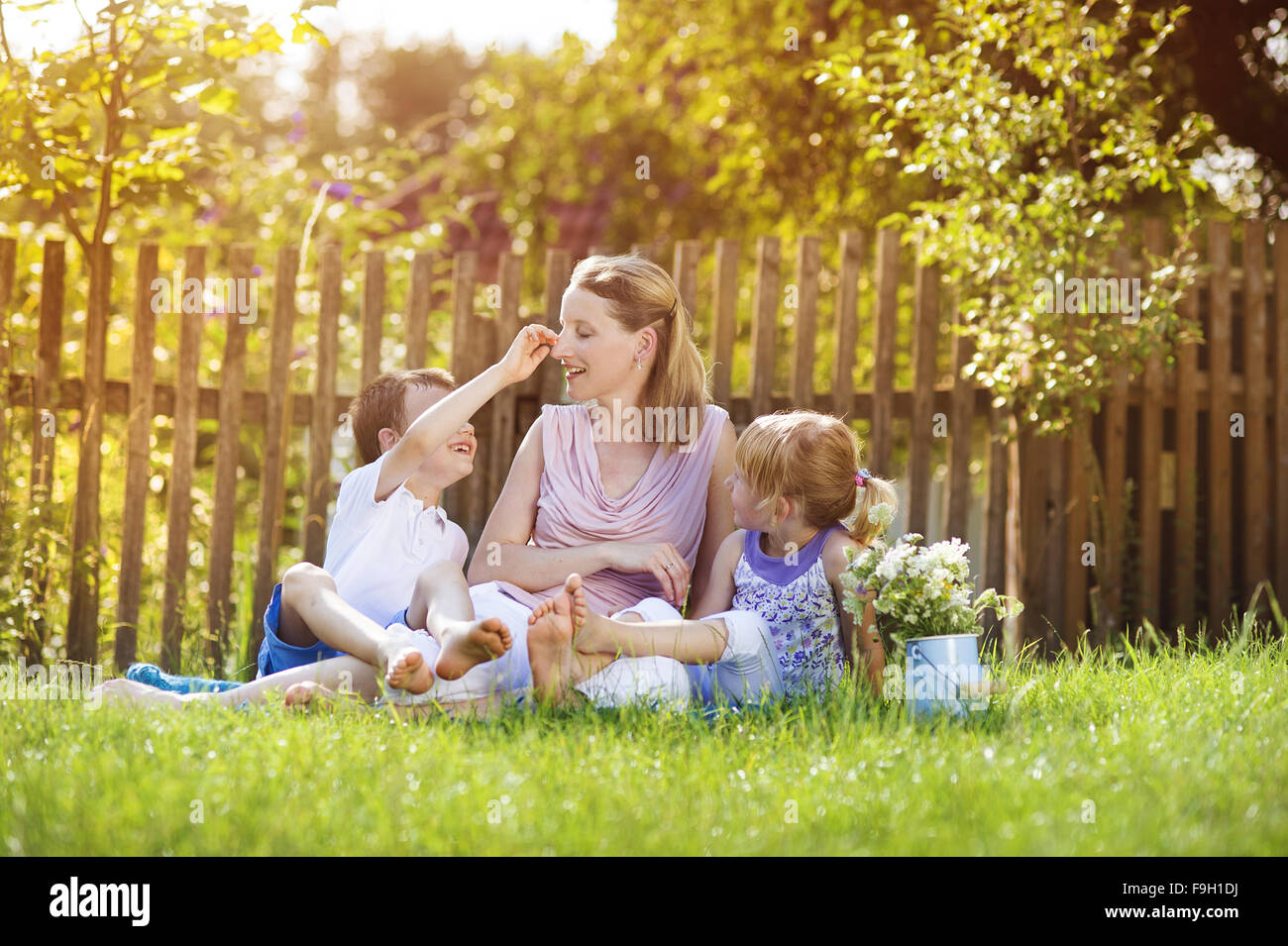 Glückliche Mutter mit ihren Kindern verbringen Zeit zusammen draußen in der grünen Natur. Stockfoto