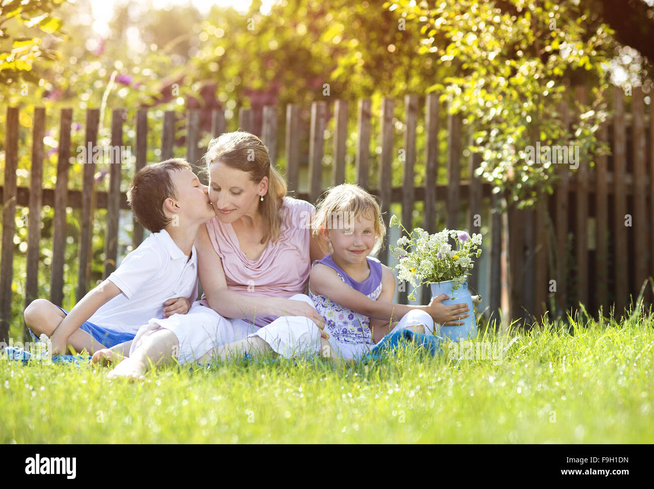 Glückliche Mutter mit ihren Kindern verbringen Zeit zusammen draußen in der grünen Natur. Stockfoto