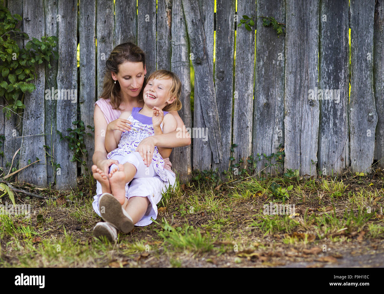 Glückliche Mutter mit ihrer Tochter verbringen Zeit zusammen draußen in der grünen Natur. Stockfoto