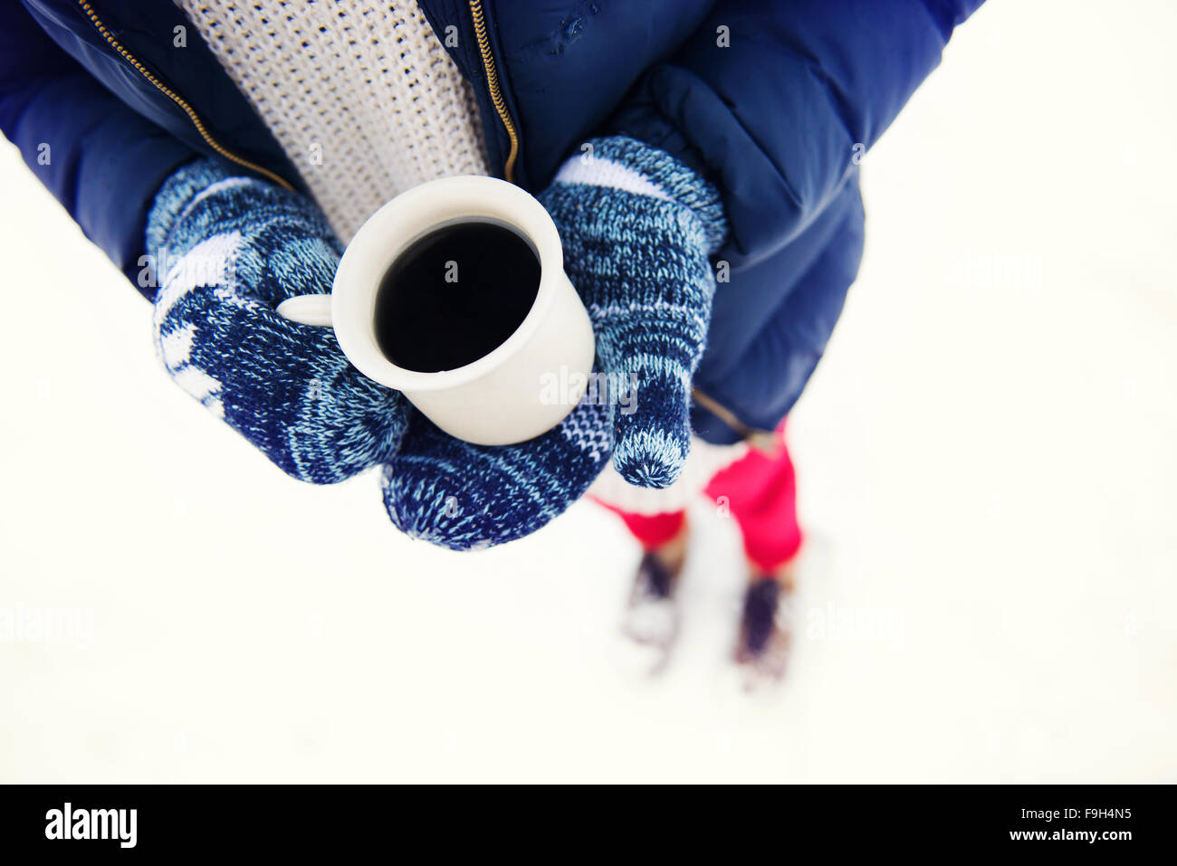 Hände der jungen Frau hält eine Tasse Kaffee draußen im Schnee Stockfoto