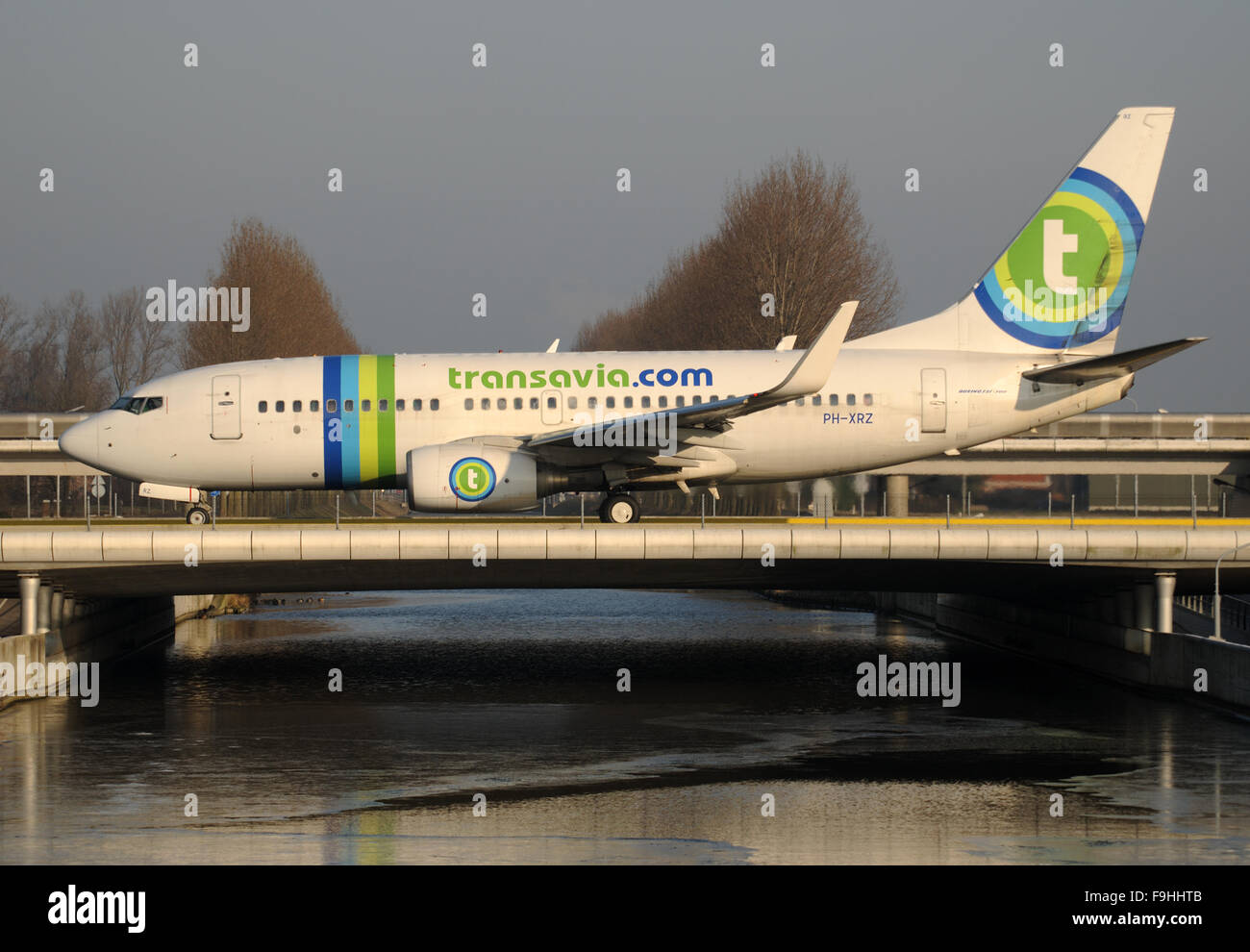 Boeing 737 der Transavia Rollen zur Polderbaan Piste über eine Brücke auf dem Flughafen Schiphol Stockfoto