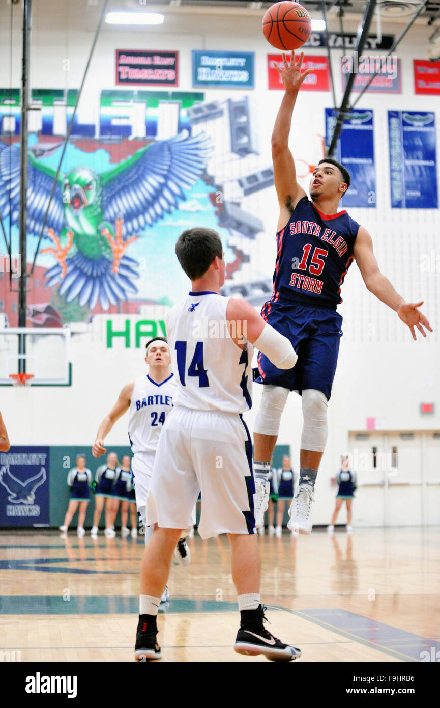 Wache erhebt sich weit über dem Boden, ein Schuss über einen Verteidiger bei einem High-School-Basketball-Spiel zu veröffentlichen. Stockfoto