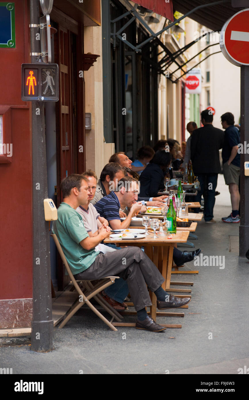 Franzosen essen Mittagessen in einem typischen Parisian Street Café auf einem schmalen Bürgersteig Stockfoto