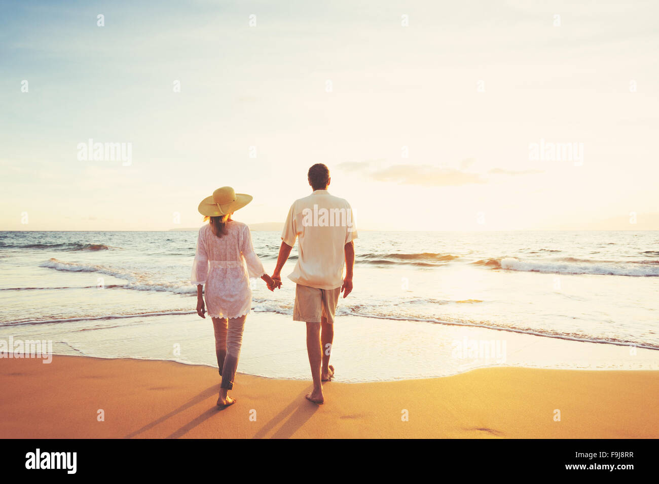 Glücklich applying romantische paar schönen Sonnenuntergang am Strand genießen. Reisen-Urlaub-Ruhestand-Lifestyle-Konzept. Stockfoto